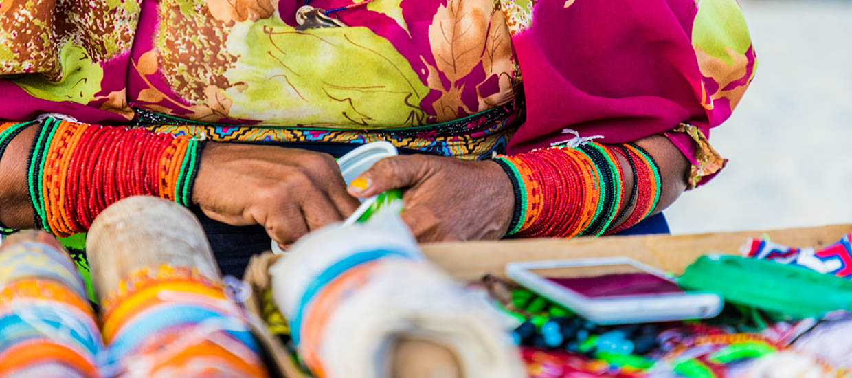 A stock photo of a Kuna woman making chaquiras.